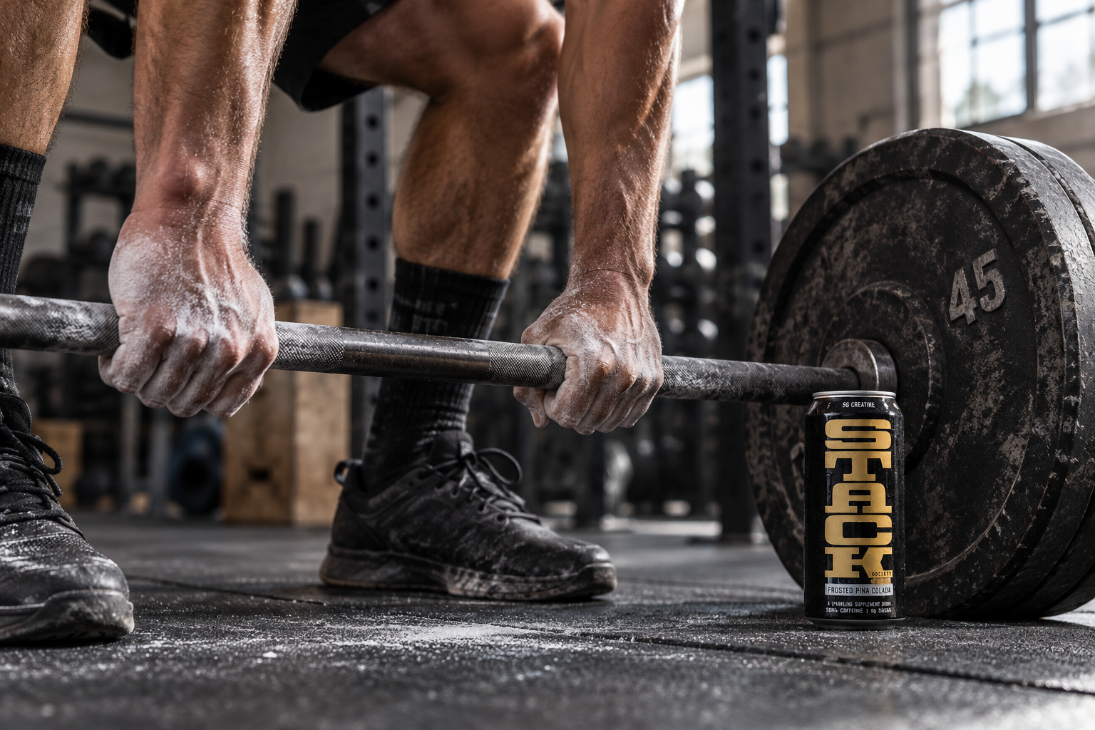 Athlete gripping a barbell beside a STACK can